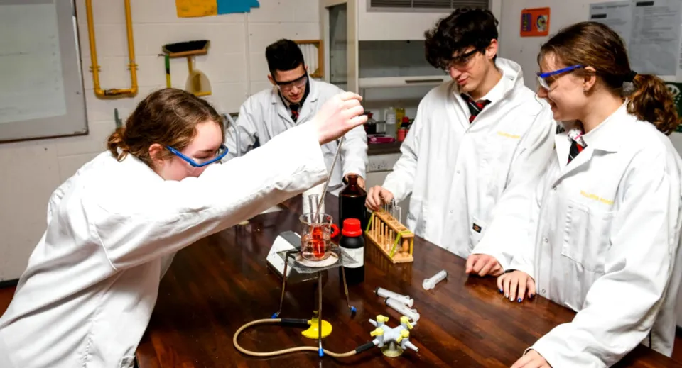 Un gruppo di studenti della Villiers School esamina apparecchiature scientifiche in laboratorio.