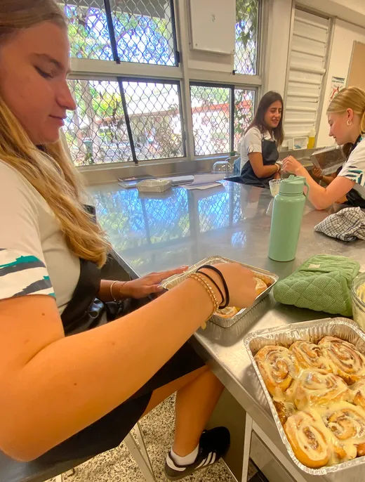 Estudiantes preparan bollos de canela juntas en la cocina del instituto
