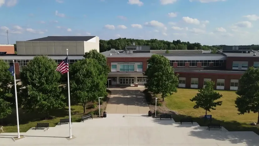 L'edificio della Clarkston High School con un grande piazzale d'ingresso, alberi e la bandiera statunitense.
