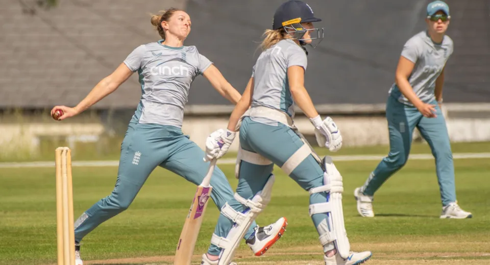 Tre atlete della Loreto Abbey Secondary School giocano a cricket su un campo in erba.