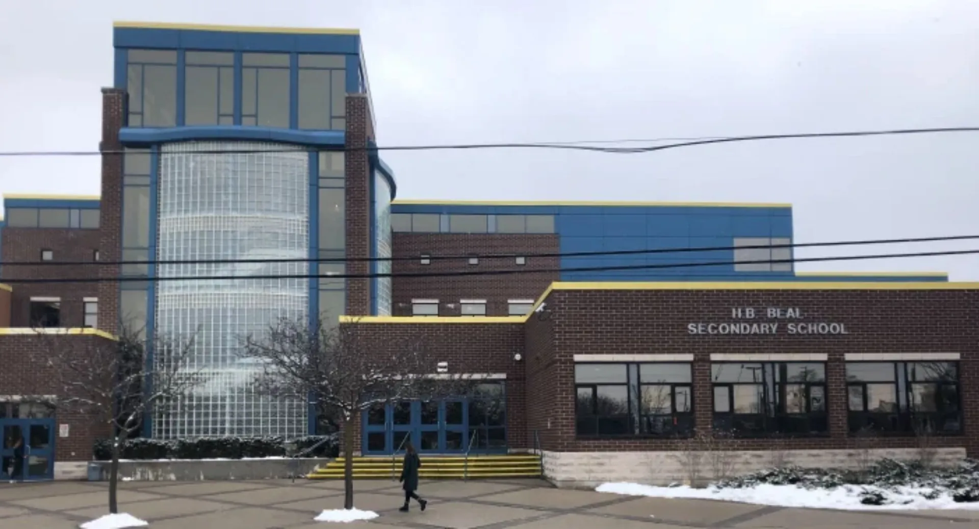 L'edificio scolastico moderno a più piani della H.B. Beal Secondary School con facciata in vetro si trova in un'area innevata.