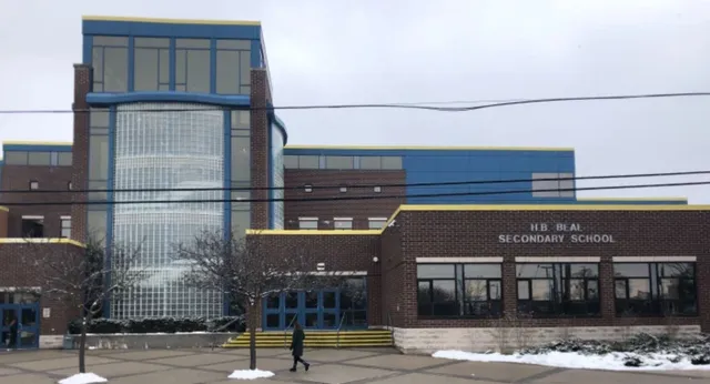 L'edificio scolastico moderno a più piani della H.B. Beal Secondary School con facciata in vetro si trova in un'area innevata.
