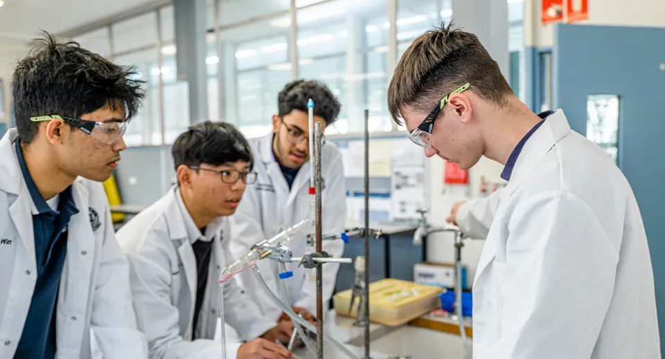 Gli studenti della Woodville High School svolgono insieme un esperimento nel laboratorio con grandi finestre.
