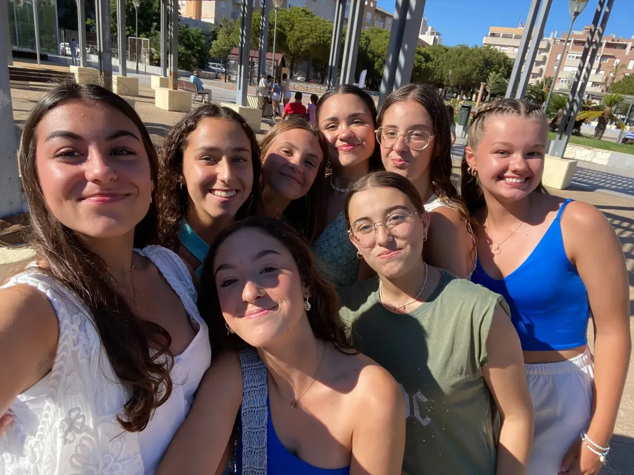 Selfie di gruppo di ragazze sorridenti in una piazza soleggiata