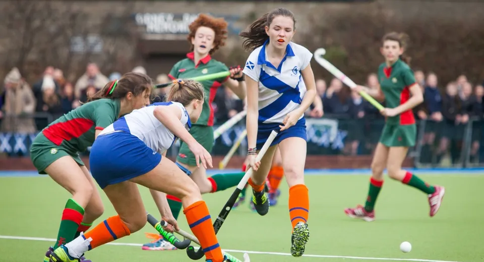 Studentesse della Holy Child Secondary School giocano un'intensa partita di hockey su prato sul campo sportivo.