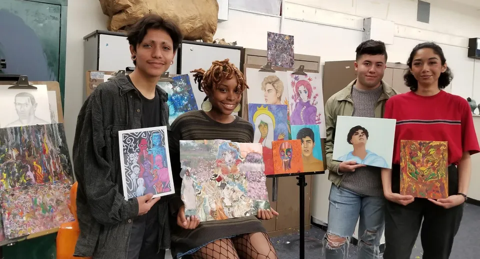 Un gruppo di studenti mostra le proprie opere d'arte variegate nello studio d'arte del Virginia Beach City Public School District.