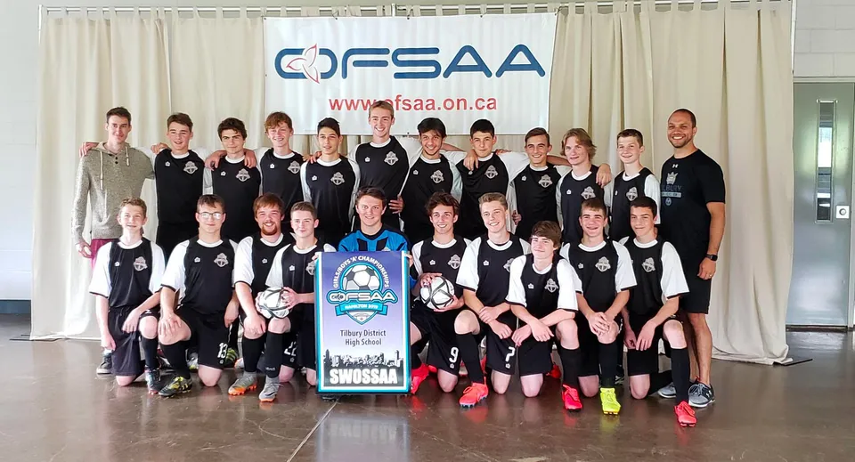 Un gruppo di studentesse della Tilbury District High School sta davanti a uno striscione OFSAA.