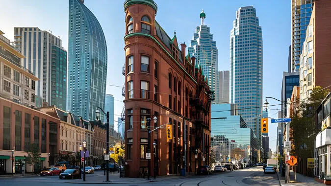El edificio de ladrillo rojo del York Mills Collegiate Institute se encuentra en primer plano frente a modernos rascacielos.