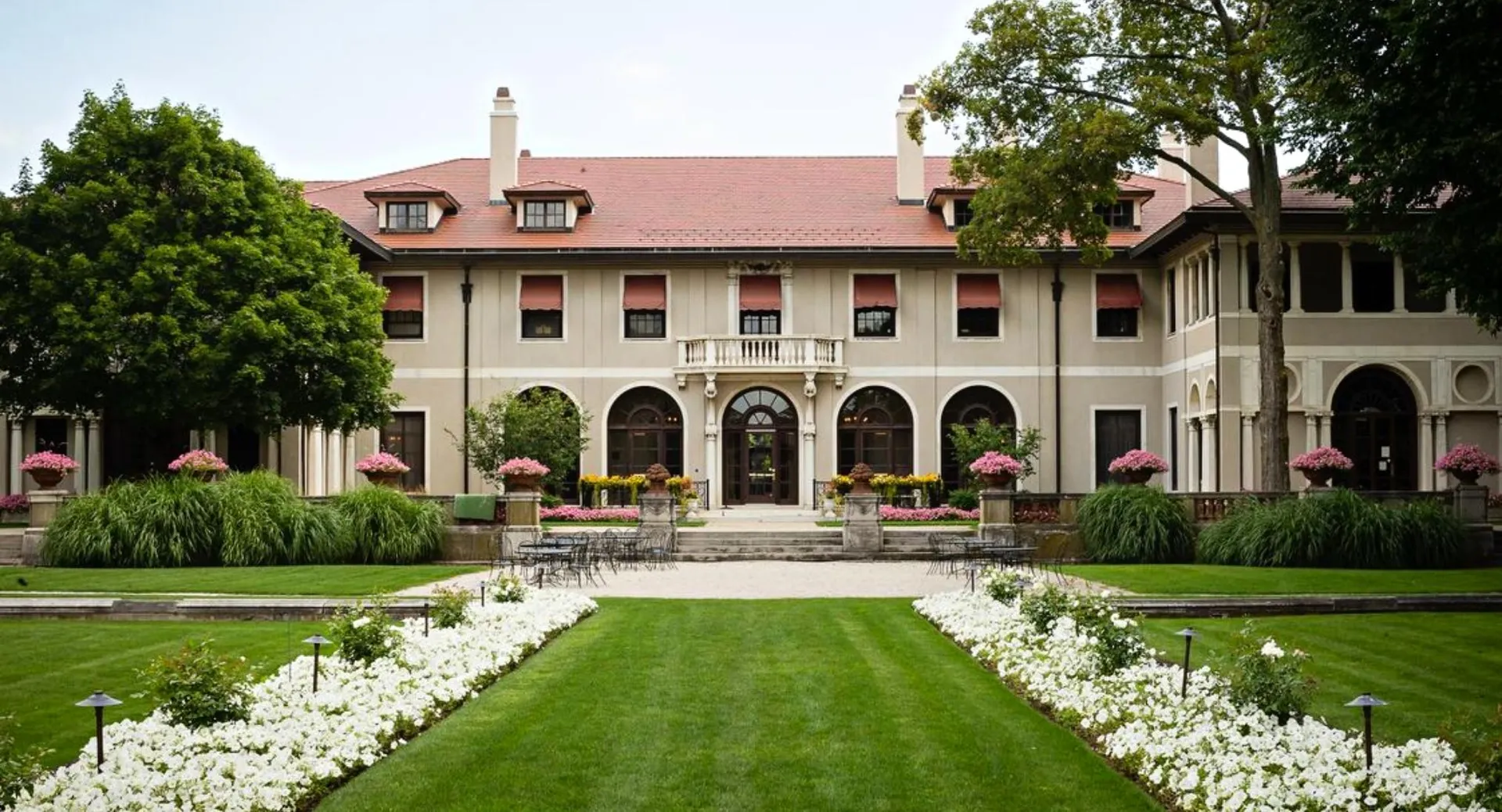 L'edificio storico della Lake Forest Academy è circondato da prati verdi e da un vialetto con fiori bianchi.