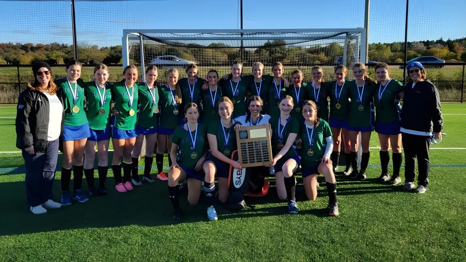 Un gruppo di studentesse della St. David Catholic Secondary School si trova sul campo da calcio davanti alla porta.