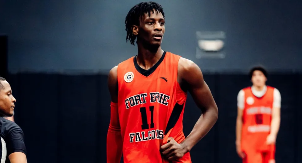 Uno studente della Fort Erie International Academy sta sul campo da basket indossando una maglia rossa da basket.