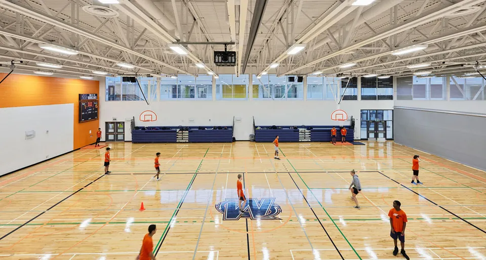 La palestra da basket della Elsie MacGill Secondary School con un grande campo da gioco e attrezzature sportive.