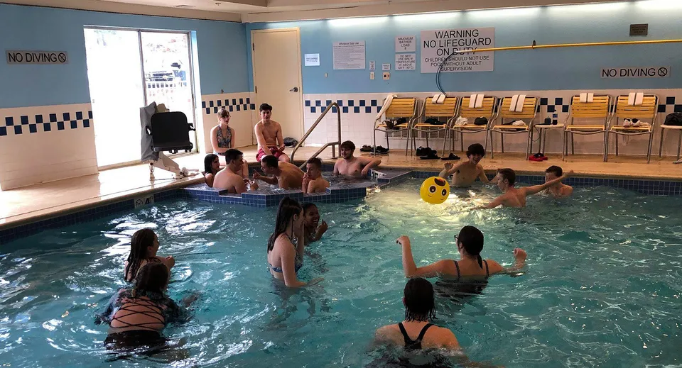 Studenti e insegnanti della Abbotsford School of Integrated Arts mentre nuotano e giocano nella piscina coperta.