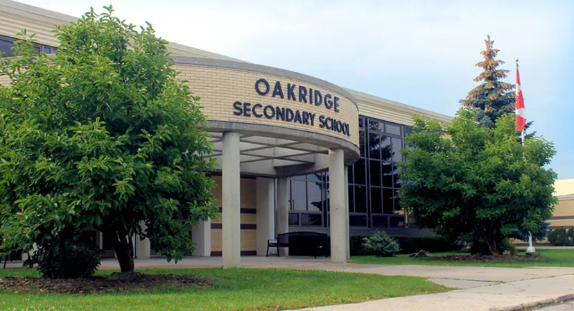 L'edificio principale della Oakridge Secondary School è circondato da aree verdi e da un prato.