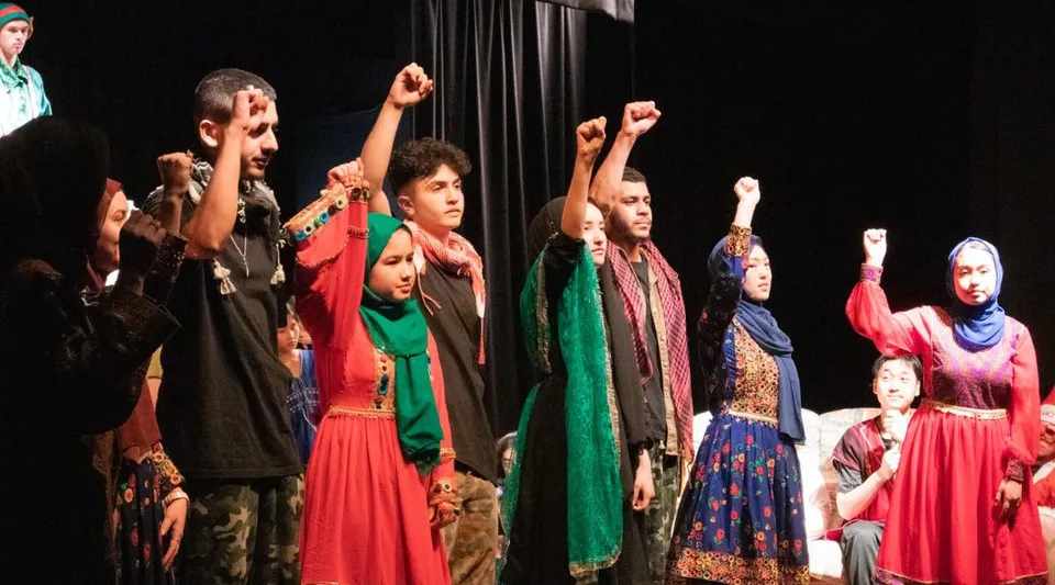 Un gruppo di studenti della Balga Senior High School si esibisce su un palco in abiti tradizionali colorati.