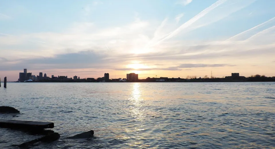 Tramonto su uno specchio d'acqua con lo skyline di una città all'orizzonte vicino alla Essex District High School.