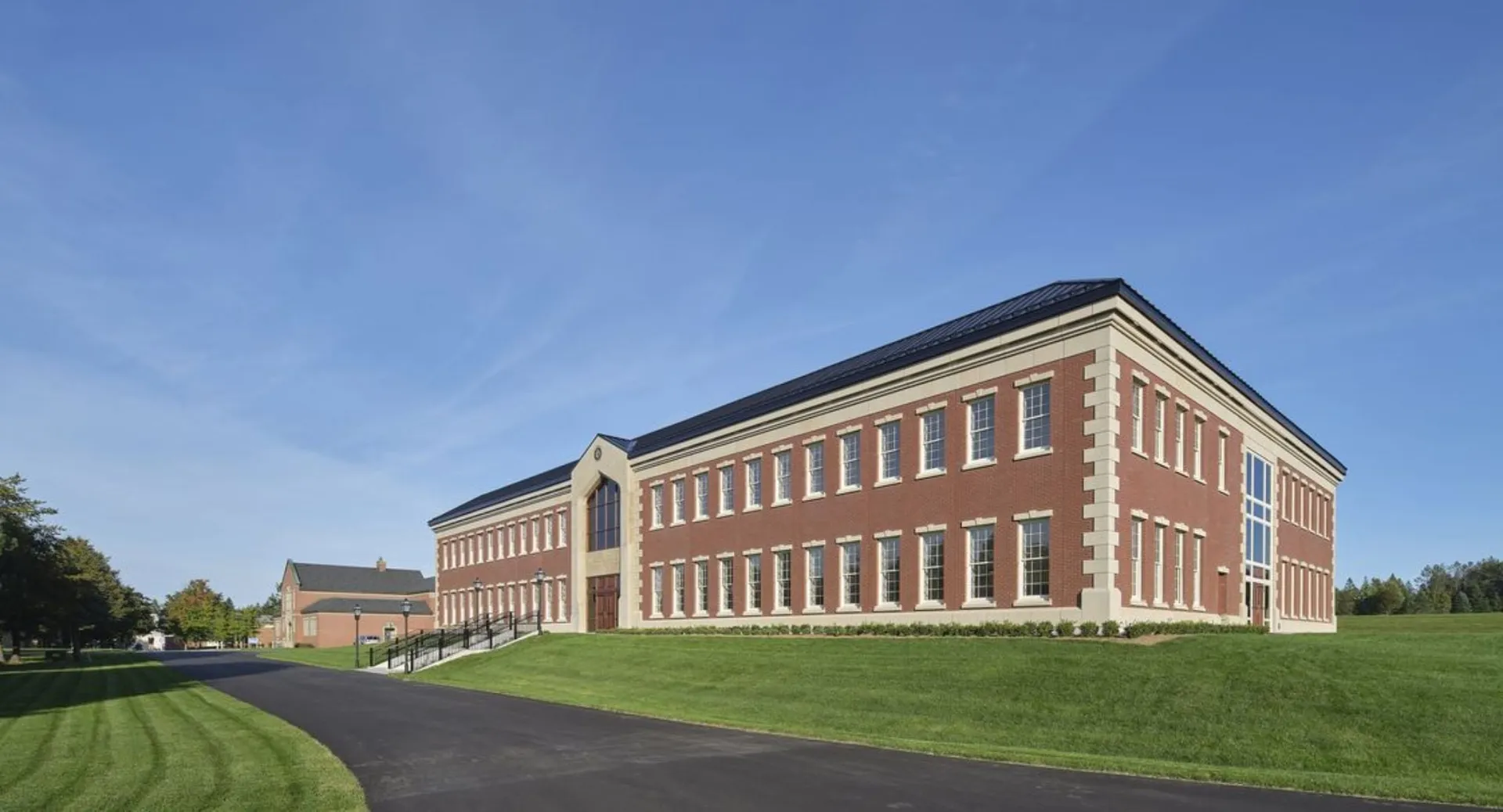 L'edificio in mattoni a più piani della Rothesay Netherwood School si trova su un prato sotto un cielo terso.