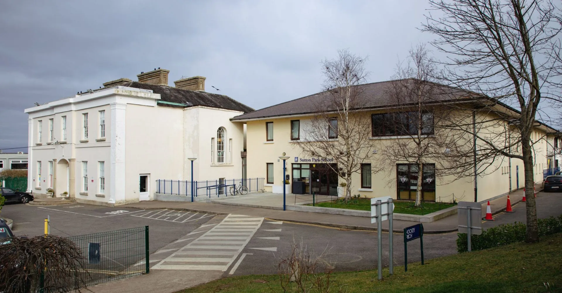 L'edificio bianco a più piani con tetto a spiovente della Sutton Park School a Dublin è circondato da alberi spogli.
