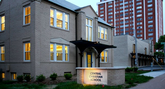 Das zweigeschossige Gebäude der Central Christian School mit einem beleuchteten Schild vor dem Eingang.