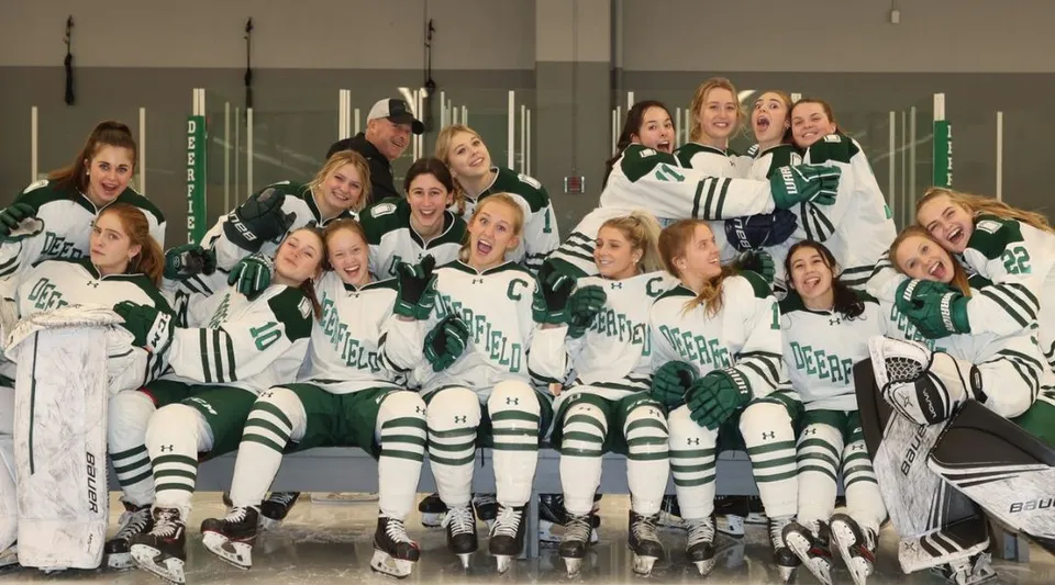 Un gruppo di giovani studentesse in divisa da hockey posa in una struttura sportiva nel campus della Deerfield Academy.