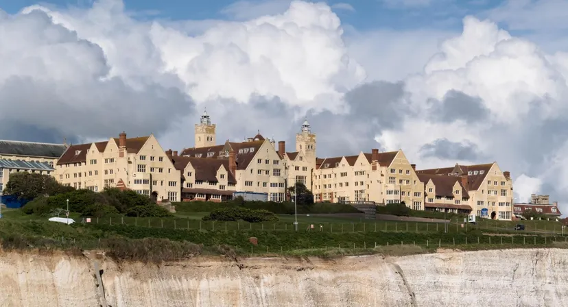 L'edificio storico della Roedean School si erge su una scogliera sotto un cielo nuvoloso.