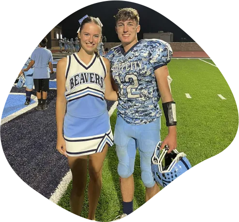 Cheerleaderin und Footballspieler auf dem Sportplatz einer High School