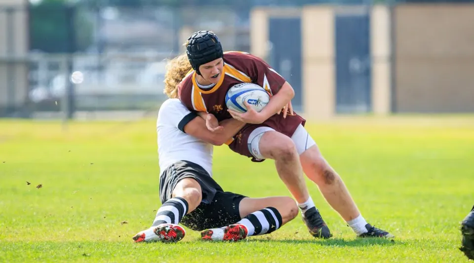 Due giocatori di rugby durante un tackle sul campo della Valley Christian High School.