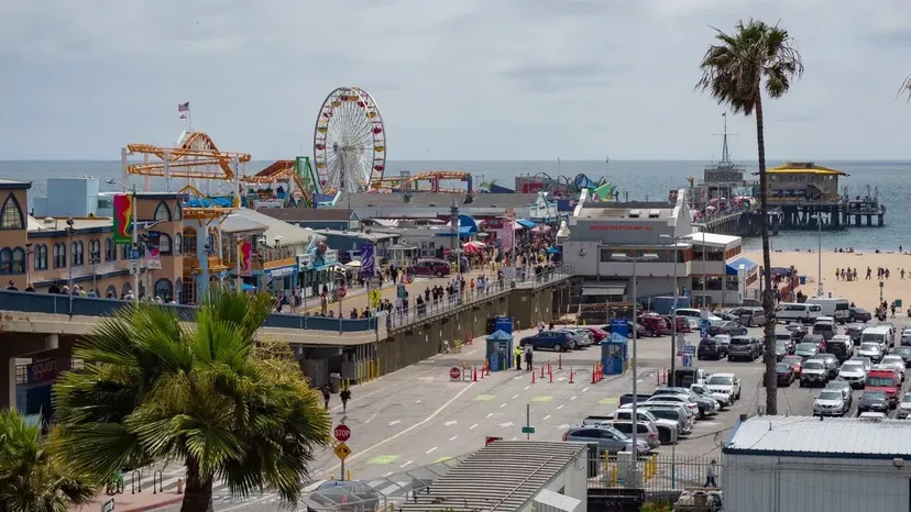 Il vivace molo con la ruota panoramica e le palme vicino al Santa Monica College in un ambiente urbano.