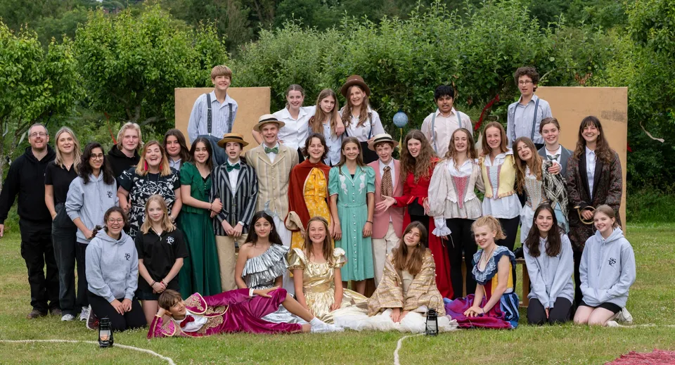 Un gruppo di studenti della Sevenoaks School all'aperto davanti a un paesaggio verde.