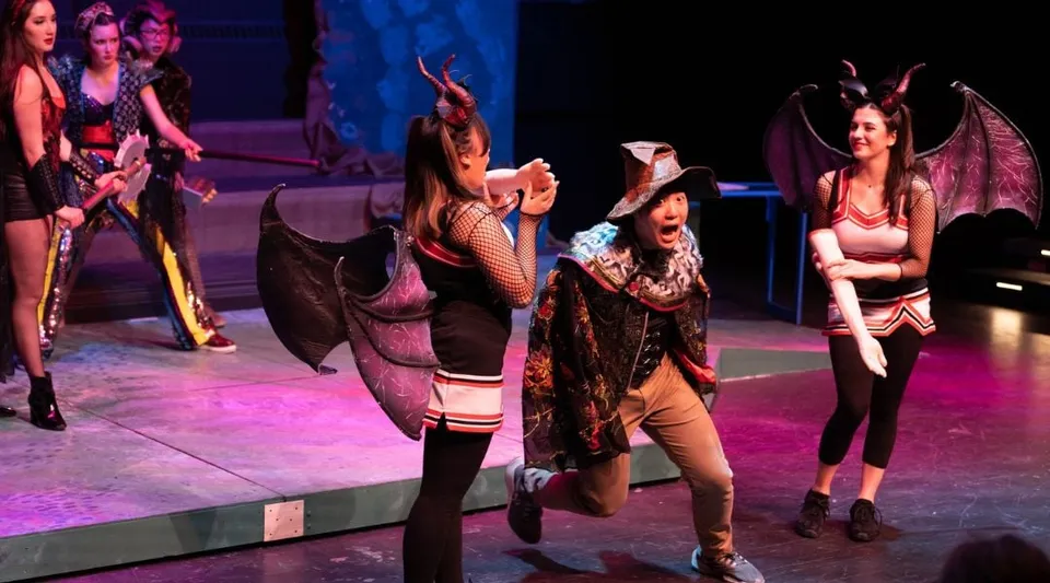 Studenti della The Taft School posano in costumi colorati sul palco durante una rappresentazione teatrale.