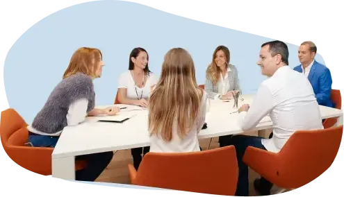 Equipo de ICES conversando alrededor de una mesa blanca en la sala de reuniones