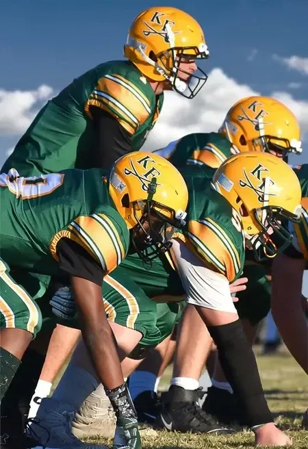 Giocatori di football americano schierati in campo durante una partita scolastica