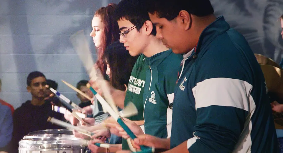 Studenti della Robert Bateman Secondary School si esibiscono insieme su un palco.