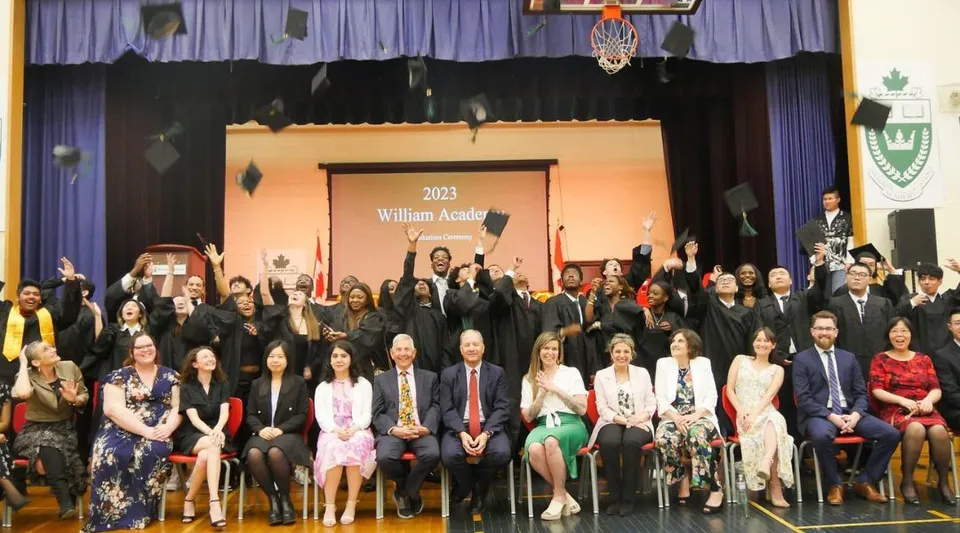 Un gruppo di studenti e adulti sul palco della William Academy durante un evento nel 2023.