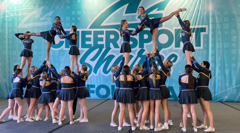 Un gruppo di cheerleader della Ascension Collegiate esegue una routine acrobatica sul palco durante l'esibizione del Cheersport Showdown.
