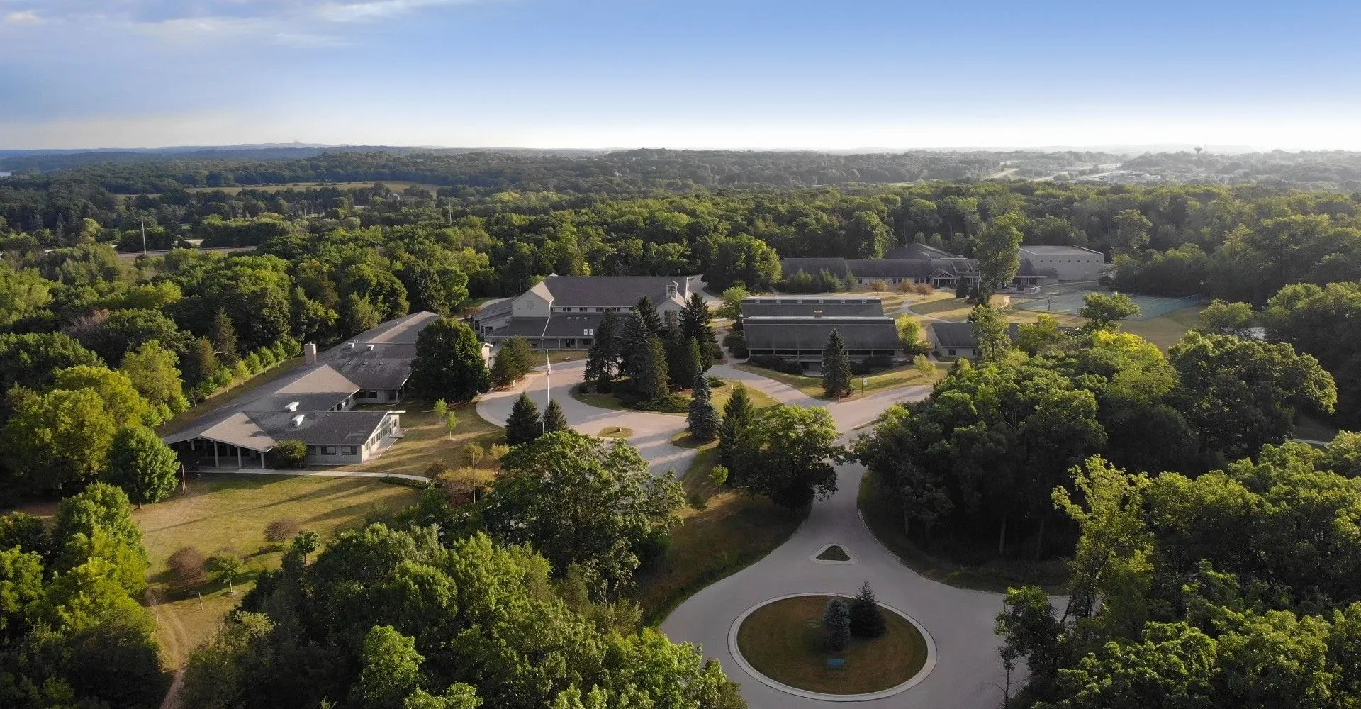 Il campus della University Lake School è immerso in un paesaggio verdeggiante con sentieri tortuosi e un'area circolare centrale.