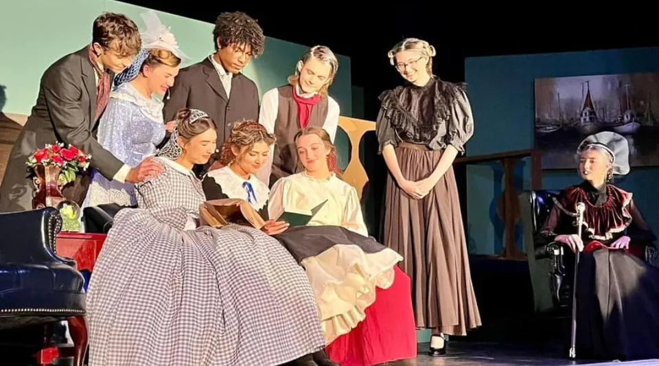 Studenti della Fayetteville Christian School si trovano su un palco con vari oggetti di scena.