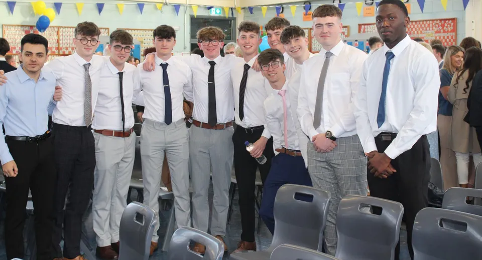 Un gruppo di studenti in abito formale è insieme in un'aula nel campus del Marist College.