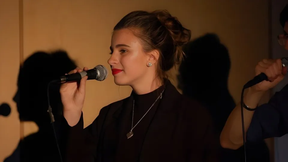 Una giovane studentessa canta con il microfono sul palco del Collège Sturgeon Heights Collegiate.