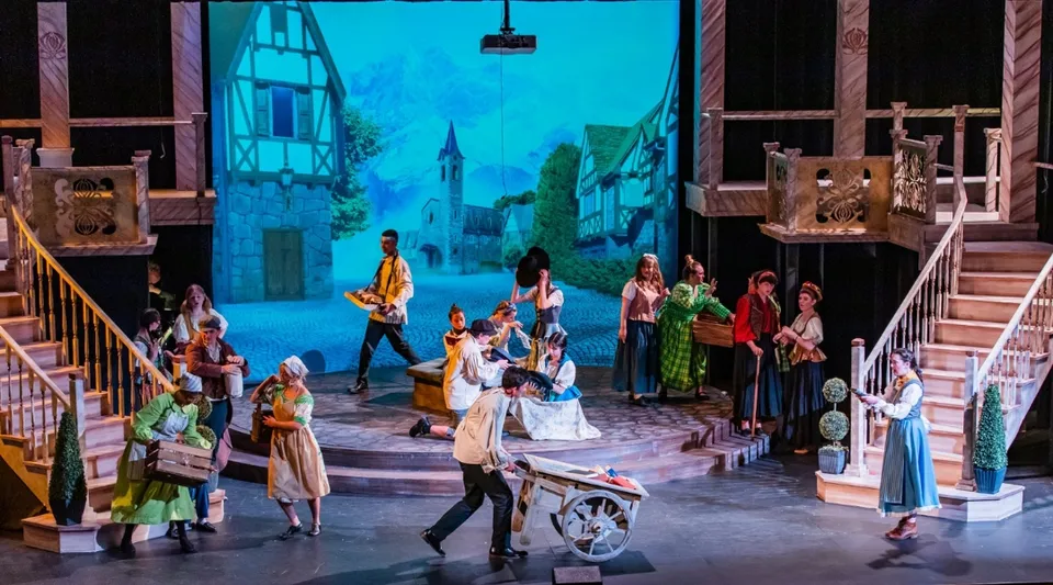 Un gruppo di studenti della Monte Vista Christian School durante una rappresentazione teatrale con costumi storici e uno scenario che ricorda una città europea.