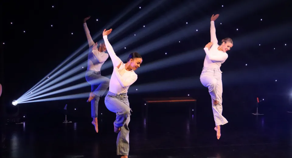 Due ballerini si esibiscono sul palco della Oundle School davanti a uno sfondo illuminato da stelle.