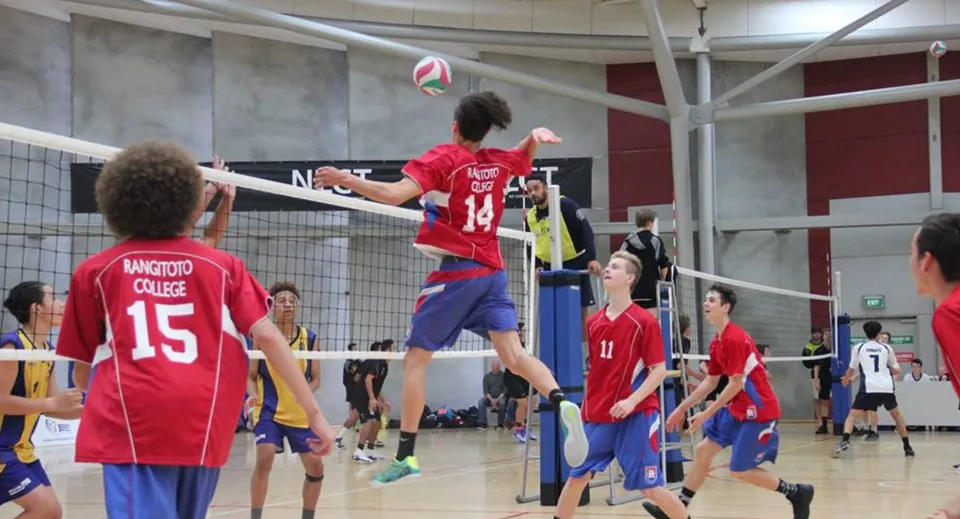 Studenti e studentesse del Rangitoto College giocano una partita di pallavolo in palestra.
