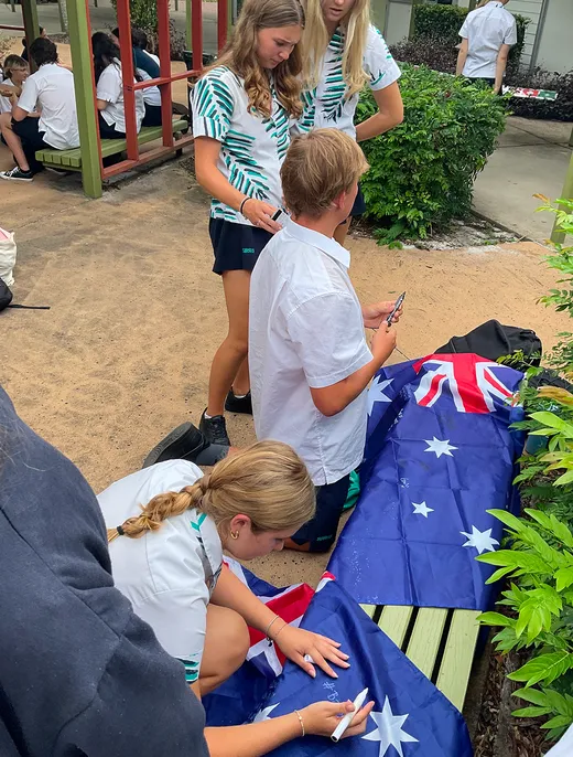 Estudiantes firman banderas australianas en el patio del instituto