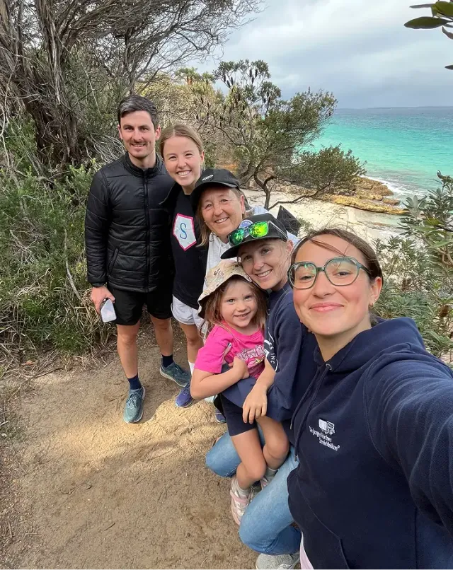 Selfie di gruppo di una famiglia su un sentiero costiero in riva al mare turchese