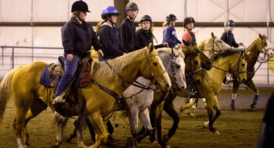 Studenti della Our Lady’s Secondary School vanno a cavallo in un maneggio coperto.