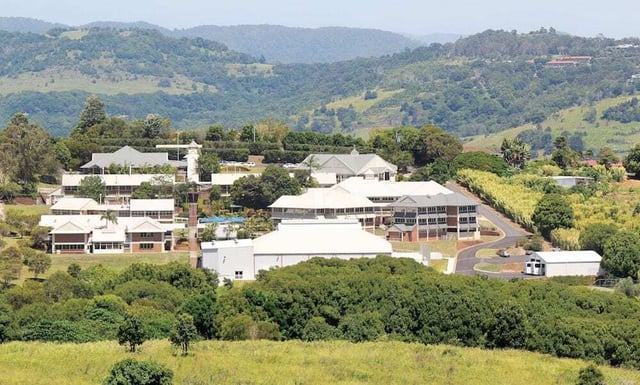 Il campus della Lindisfarne Anglican Grammar School è circondato da colline verdi e alberi.