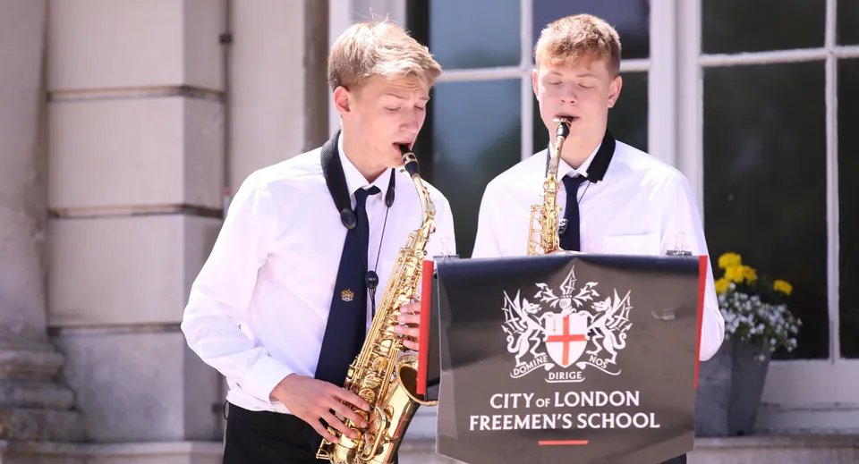 Due studenti della City of London Freemen’s School suonano il sassofono all'aperto.