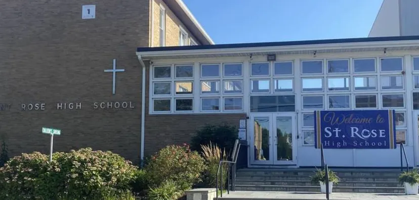 Si vede l'edificio in mattoni della St. Rose High School con grandi finestre e un accogliente cartello all'ingresso.