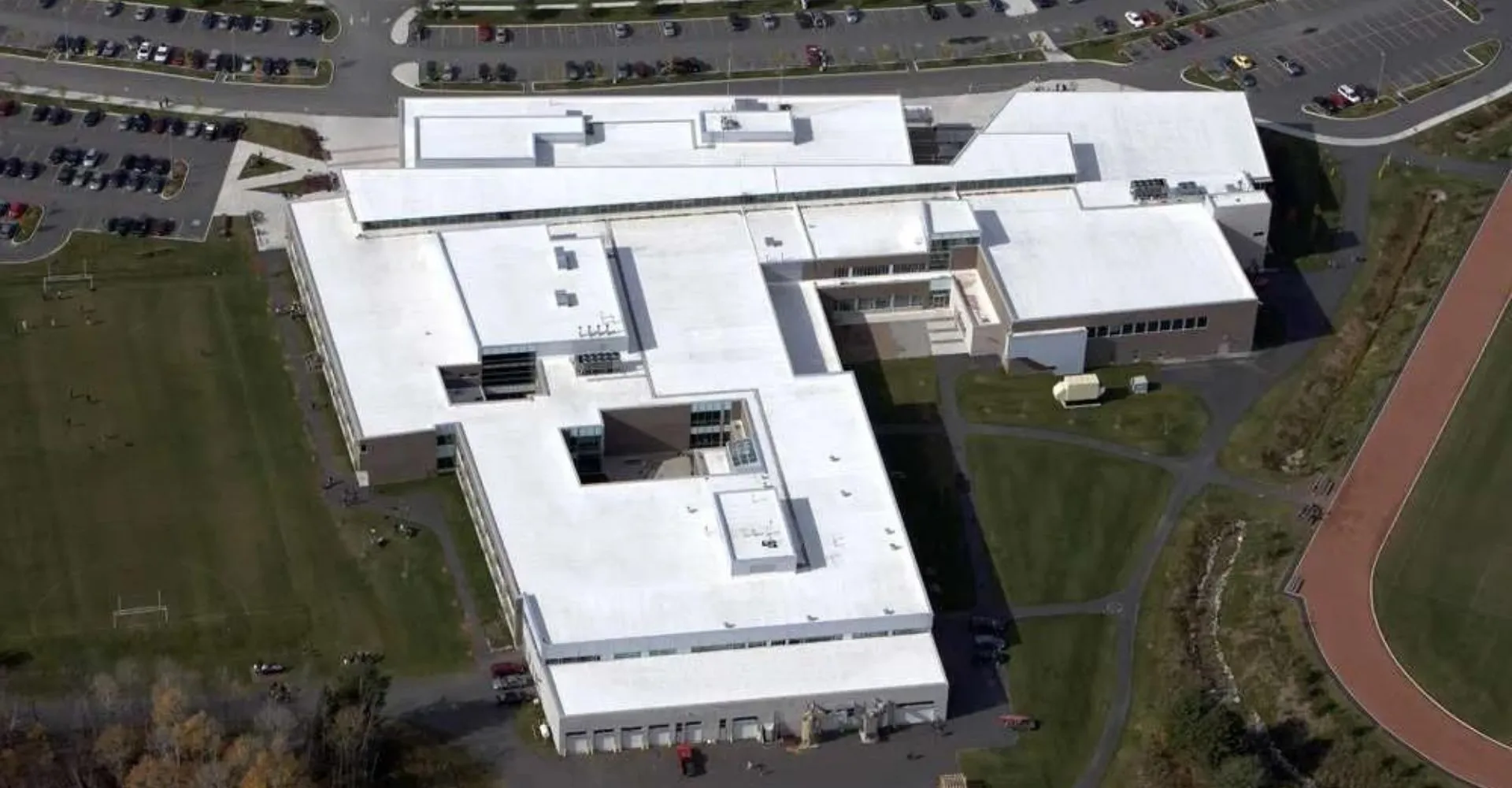 L'edificio scolastico moderno a più piani della Bracebridge and Muskoka Lakes Secondary School con parcheggio e aree verdi sullo sfondo.