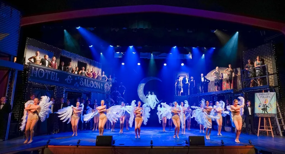 Studenti e studentesse della Yeronga State High School si esibiscono in uno spettacolo di danza su un palco colorato con scenografia teatrale.